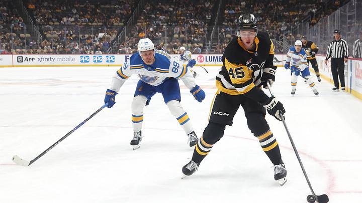 Oct 27, 2025; Pittsburgh, Pennsylvania, USA;  Pittsburgh Penguins defenseman Harrison Brunicke (45) handles the puck ahead of St. Louis Blues left wing Pavel Buchnevich (89) during the first period  at PPG Paints Arena. Mandatory Credit: Charles LeClaire-Imagn Images