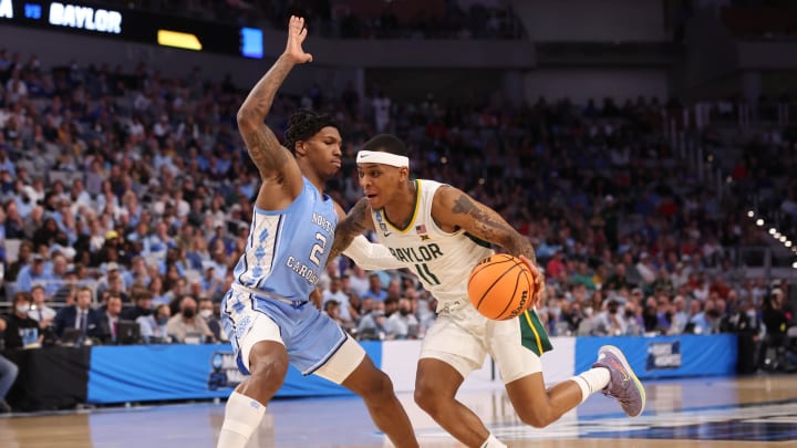 Baylor Bears guard James Akinjo (11) drives against North Carolina Tar Heels guard Caleb Love (2) during the second round of the 2022 NCAA Tournament at Dickies Arena. 