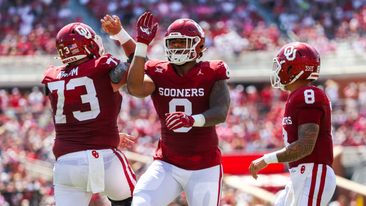 Oklahoma Sooners offensive lineman Andrew Raym (73) and Oklahoma Sooners quarterback Dillon Gabriel (8) and Oklahoma Sooners defensive lineman Jonah Laulu (8) reacts after a score during the game against the Arkansas State Red Wolves.