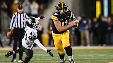 Nov 22, 2025; Iowa City, Iowa, USA; Iowa Hawkeyes quarterback Mark Gronowski (11) scrambles for yards as Michigan State Spartans safety Malik Spencer (43) misses the tackle during the fourth quarter at Kinnick Stadium. Mandatory Credit: Jeffrey Becker-Imagn Images