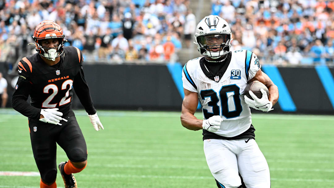 Sep 29, 2024; Charlotte, North Carolina, USA; Carolina Panthers running back Chuba Hubbard (30) runs down the sideline as Cincinnati Bengals safety Geno Stone (22) chases in the second quarter at Bank of America Stadium. Mandatory Credit: Bob Donnan-Imagn Images