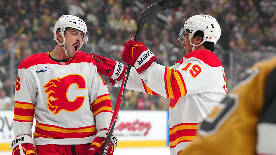 Apr 2, 2026; Las Vegas, Nevada, USA; Calgary Flames center Morgan Frost (16) celebrates with defenseman Zayne Parekh (19) after scoring a goal against the Vegas Golden Knights during the first period at T-Mobile Arena. Mandatory Credit: Stephen R. Sylvanie-Imagn Images