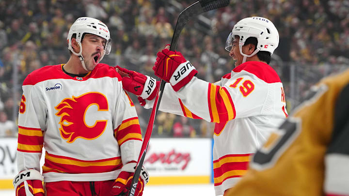 Apr 2, 2026; Las Vegas, Nevada, USA; Calgary Flames center Morgan Frost (16) celebrates with defenseman Zayne Parekh (19) after scoring a goal against the Vegas Golden Knights during the first period at T-Mobile Arena. Mandatory Credit: Stephen R. Sylvanie-Imagn Images