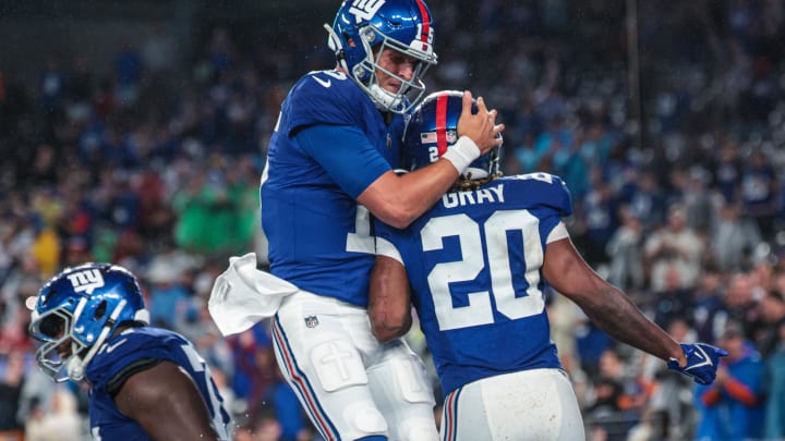 Aug 8, 2024; East Rutherford, New Jersey, USA; New York Giants running back Eric Gray (20) celebrates his touchdown with quarterback Tommy DeVito (15) during the first half against the Detroit Lions at MetLife Stadium.  