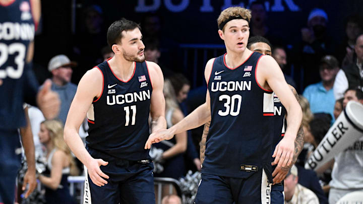 Dec 21, 2024; Indianapolis, Indiana, USA; Connecticut Huskies forward Alex Karaban (11) and forward Liam McNeeley (30) high-five after defeating the Butler Bulldogs at Hinkle Fieldhouse. Mandatory Credit: Robert Goddin-Imagn Images