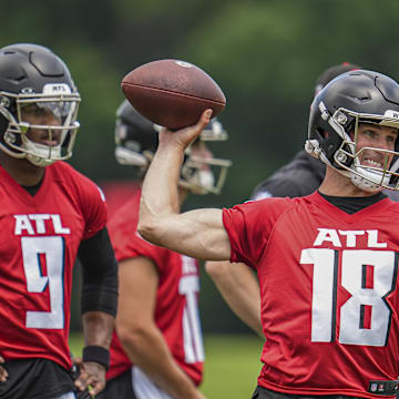 Kirk Cousins throws while Michael Penix Jr. watches during Falcons OTAs in 2024.
