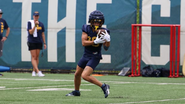 West Virginia University receiver Preston Fox hauls in a punt during fall camp (2024).