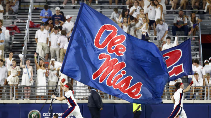 Aug 31, 2024; Oxford, Mississippi, USA; Mississippi Rebels Cheerleaders run the Ole Miss flag across the field after a touchdown during the second half against the Furman Paladins at Vaught-Hemingway Stadium. Mandatory Credit: Petre Thomas-USA TODAY Sports