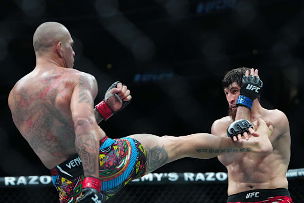 Alex Pereira (red gloves) fights Magomed Ankalaev (blue gloves) during UFC 313 at T-Mobile Arena. 