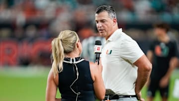 Nov 8, 2025; Miami Gardens, Florida, USA; Miami Hurricanes head coach Mario Cristobal is interviewed by ESPN reporter Kris Burden after the third quarter in a game against the Syracuse Orange at Hard Rock Stadium. Mandatory Credit: Jeff Romance-Imagn Images