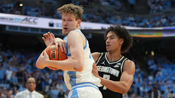 Dec 7, 2025; Chapel Hill, North Carolina, USA;  North Carolina Tar Heels center Henri Veesaar (13) with the ball as Georgetown Hoyas forward Isaiah Abraham (7) defends in the second half at Dean E. Smith Center. Mandatory Credit: Bob Donnan-Imagn Images