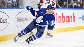 Mar 15, 2025; Toronto, Ontario, CAN;  Toronto Maple Leafs forward Nick Robertson (89) pivots away from a bodycheck from Ottawa Senators defenseman Nikolas Matinpalo (33) in the third period at Scotiabank Arena. Mandatory Credit: Dan Hamilton-Imagn Images