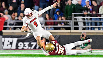 Oct 25, 2024; Chestnut Hill, Massachusetts, USA; Louisville Cardinals quarterback Tyler Shough (9) is tackled by Boston College Eagles defensive back Omar Thornton (30) during the first half at Alumni Stadium. Mandatory Credit: Eric Canha-Imagn Images