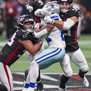 Nov 3, 2024; Atlanta, Georgia, USA; Dallas Cowboys running back Rico Dowdle (23) is tackled by Atlanta Falcons linebackers Nate Landman (53) and Kaden Elliss (55) during the second half at Mercedes-Benz Stadium. Mandatory Credit: Dale Zanine-Imagn Images