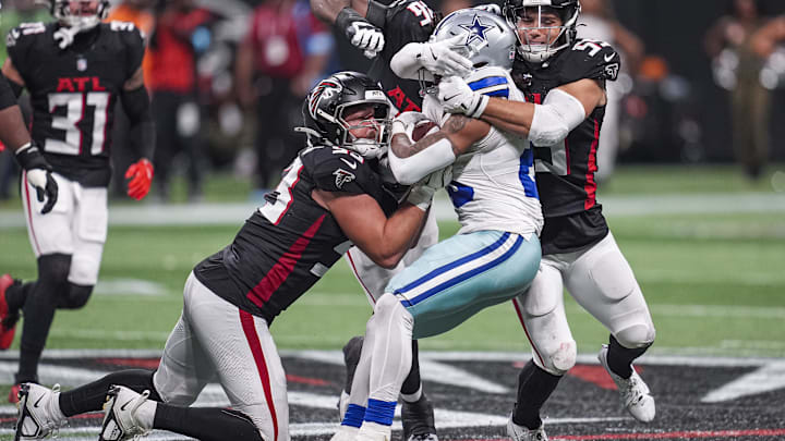 Nov 3, 2024; Atlanta, Georgia, USA; Dallas Cowboys running back Rico Dowdle (23) is tackled by Atlanta Falcons linebackers Nate Landman (53) and Kaden Elliss (55) during the second half at Mercedes-Benz Stadium. Mandatory Credit: Dale Zanine-Imagn Images Nov 3, 2024; Atlanta, Georgia, USA; Dallas Cowboys running back Rico Dowdle (23) is tackled by Atlanta Falcons linebackers Nate Landman (53) and Kaden Elliss (55) during the second half at Mercedes-Benz Stadium. Mandatory Credit: Dale Zanine-Imagn Images