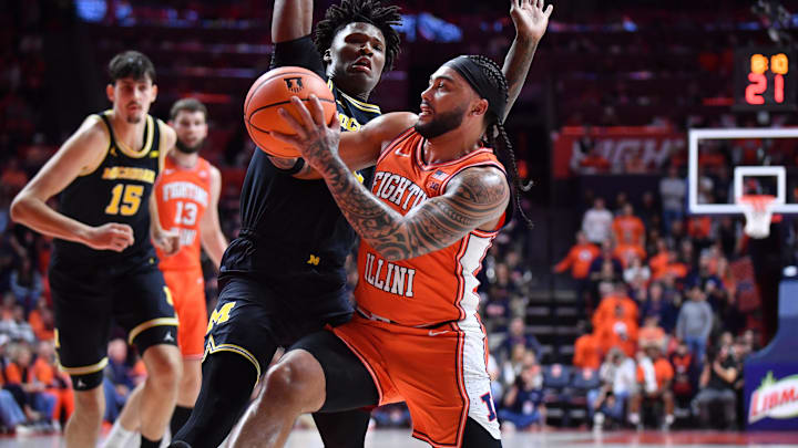 Feb 27, 2026; Champaign, Illinois, USA;  Illinois Fighting Illini guard Kylan Boswell (4) drives to the basket as Michigan Wolverines guard L.J. Cason (2) defends during the first half at State Farm Center. Mandatory Credit: Ron Johnson-Imagn Images