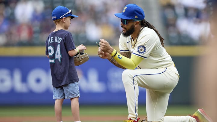 Seattle Mariners shortstop J.P. Crawford signs a ball before a game against the Houston Astros on July 21 at T-Mobile Park.