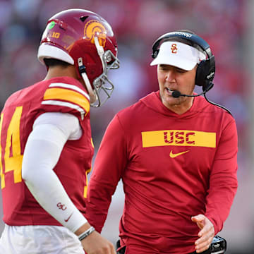 Nov 16, 2024; Los Angeles, California, USA; Southern California Trojans head coach Lincoln Riley greets quarterback Jayden Maiava (14) after scoring a touchdown against the Nebraska Cornhuskers during the second half at the Los Angeles Memorial Coliseum. Mandatory Credit: Gary A. Vasquez-Imagn Images