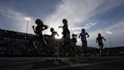 Silhouettes of  Avi'Tal Wilson-Perteete of UNLV and Samantha Huerta of Cal State Fullerton leading a women's 800m heat during the NCAA West Preliminary at Hornet Stadium. 
