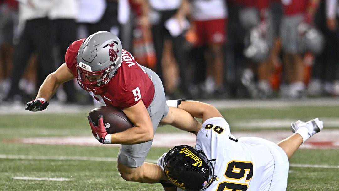 Aug 30, 2025; Pullman, Washington, USA; Washington State Cougars running back Kirby Vorhees (9) is tackled in the backfield by Idaho Vandals defensive lineman Trevor Miller (99) in the first half at Gesa Field at Martin Stadium.