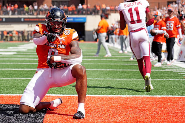 Oklahoma State's Ollie Gordon II celebrates a 2-point conversion front of Oklahoma's Jaylon Braxton in double overtime. 