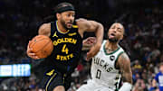 Feb 10, 2025; Milwaukee, Wisconsin, USA;  Golden State Warriors forward Moses Moody (4) drives for the basket against Milwaukee Bucks guard Damian Lillard (0) in the second quarter at Fiserv Forum. Mandatory Credit: Benny Sieu-Imagn Images