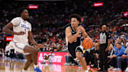 Nov 14, 2025; Inglewood, California, USA;  Arizona Wildcats guard Brayden Burries (5) drives to the basket against UCLA Bruins center Xavier Booker (1) during the first half of the Hall of Fame Series game at Intuit Dome. Mandatory Credit: Kiyoshi Mio-Imagn Images
