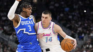 Feb 23, 2025; Milwaukee, Wisconsin, USA;  Miami Heat guard Tyler Herro (14) dribbles the ball under pressure from Milwaukee Bucks guard Kevin Porter Jr. (3) during the fourth quarter at Fiserv Forum. Mandatory Credit: Jeff Hanisch-Imagn Images