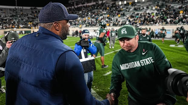 Michigan head coach Sherrone Moore shakes hands with Michigan State head coach Jonathan Smit