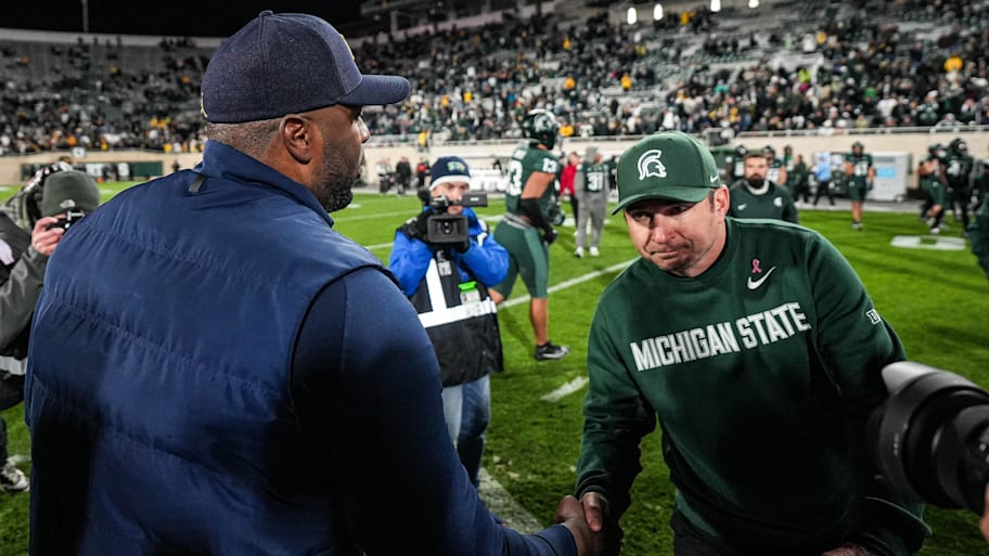 Michigan head coach Sherrone Moore shakes hands with Michigan State head coach Jonathan Smit