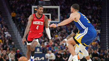 Houston Rockets guard Jalen Green dribbles the ball next to Golden State Warriors guard Stephen Curry.
