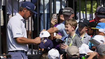Sep 21, 2024; Carrolton, Texas, USA; Bryson DeChambeau of the Crushers GC signs autographs for young fans near the first tee during the LIV Golf Dallas Team Championship Semifinals at Maridoe Golf Club. Mandatory Credit: Raymond Carlin III-Imagn Images