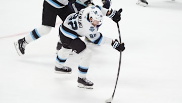 Dec 12, 2024; Denver, Colorado, USA; Utah Hockey Club center Kevin Stenlund (82) shoots and scores an empty net goal in the third period against the Colorado Avalanche at Ball Arena. Mandatory Credit: Ron Chenoy-Imagn Images