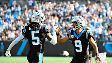 Nov 9, 2025; Charlotte, North Carolina, USA;  Carolina Panthers running back Rico Dowdle (5) celebrates with quarterback Bryce Young (9) after scoring a touchdown  in the first quarter at Bank of America Stadium. Mandatory Credit: Bob Donnan-Imagn Images