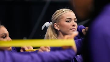 LSU gymnast Livvy Dunne stretches with teammates before Session 2 of the SEC Gymnastics Tournament.