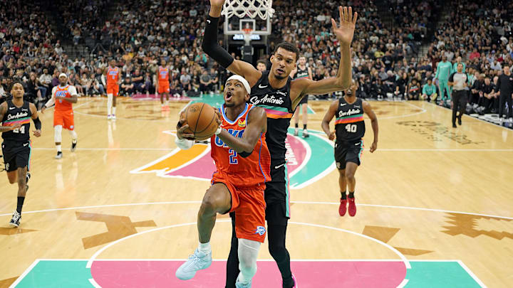 Dec 23, 2025; San Antonio, Texas, USA; Oklahoma City Thunder guard Shai Gilgeous-Alexander (2) drives to the basket past San Antonio Spurs forward Victor Wembanyama (1) during the first half at Frost Bank Center. Mandatory Credit: Scott Wachter-Imagn Images