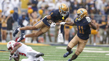 Sep 27, 2025; Morgantown, West Virginia, USA; West Virginia Mountaineers wide receiver Cam Vaughn (4) jumps over Utah Utes cornerback Elijah Davis (9) during the first quarter at Milan Puskar Stadium. Mandatory Credit: Ben Queen-Imagn Images