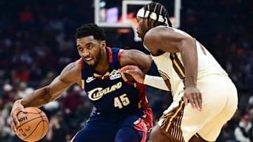 Dec 6, 2025; Cleveland, Ohio, USA; Cleveland Cavaliers guard Donovan Mitchell (45) works against Golden State Warriors guard Buddy Hield (7) during the first half at Rocket Arena. Mandatory Credit: Ken Blaze-Imagn Images
