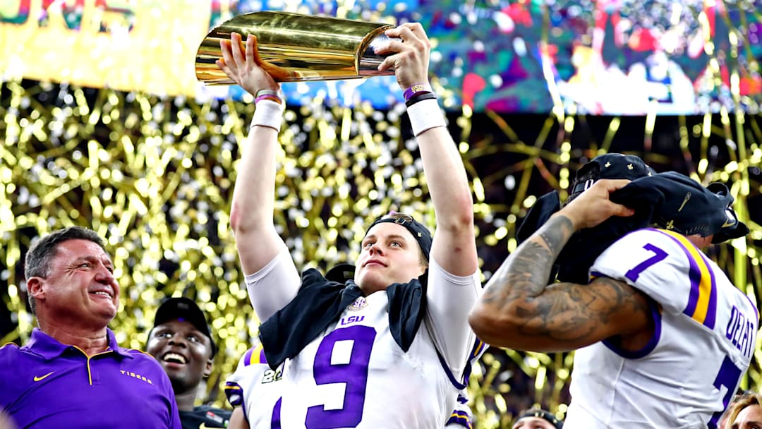 Jan 13, 2020; New Orleans, Louisiana, USA; LSU Tigers head coach Ed Orgeron and LSU Tigers quarterback Joe Burrow (9) celebrate with the National Championship trophy after beating Clemson Tigers in the College Football Playoff national championship game at Mercedes-Benz Superdome. Mandatory Credit: Matthew Emmons-Imagn Images Jan 13, 2020; New Orleans, Louisiana, USA; LSU Tigers head coach Ed Orgeron and LSU Tigers quarterback Joe Burrow (9) celebrate with the National Championship trophy after beating Clemson Tigers in the College Football Playoff national championship game at Mercedes-Benz Superdome. Mandatory Credit: Matthew Emmons-Imagn Images