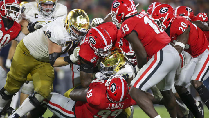 Sep 21, 2019; Athens, GA, USA; Notre Dame Fighting Irish running back Tony Jones Jr. (6) is tackled by Georgia Bulldogs defensive lineman Jordan Davis (99) in the third quarter at Sanford Stadium.