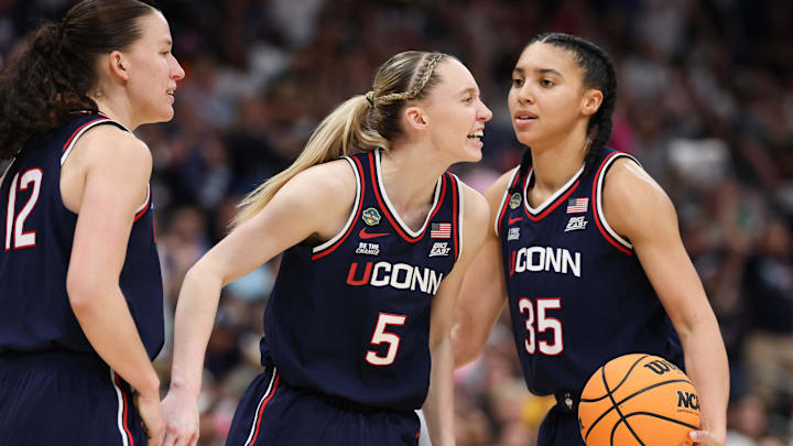 Connecticut Huskies guard Paige Bueckers (5) reacts with teammates guard Ashlynn Shade (12) and guard Azzi Fudd 