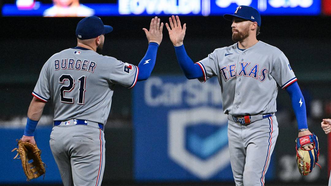 Texas Rangers right fielder Brandon Nimmo (24) celebrates with first baseman Jake Burger (21). 