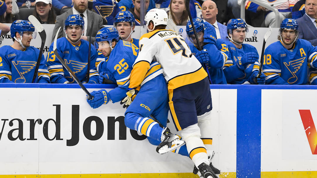 Dec 27, 2025; St. Louis, Missouri, USA; St. Louis Blues right wing Jordan Kyrou (25) is checked by Nashville Predators right wing Michael McCarron (47) during the second period at Enterprise Center. Mandatory Credit: Jeff Curry-Imagn Images