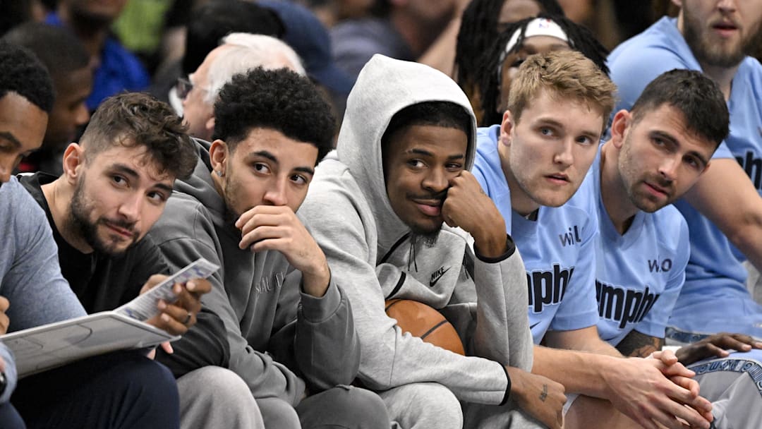 Nov 22, 2025; Dallas, Texas, USA; Memphis Grizzlies guard Ja Morant (center) looks on from the team bench during the first quarter against the Dallas Mavericks at the American Airlines Center. Mandatory Credit: Jerome Miron-Imagn Images