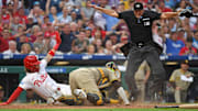 Jun 30, 2025; Philadelphia, Pennsylvania, USA; umpire Chad Fairchild (4) calls Philadelphia Phillies second base Bryson Stott (5) safe at home ahead of tag by San Diego Padres catcher Martín Maldonado (15) during the fourth inning at Citizens Bank Park.