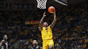 Feb 19, 2025; Morgantown, West Virginia, USA; West Virginia Mountaineers guard Javon Small (7) shoots a layup during the first half against the Cincinnati Bearcats at WVU Coliseum. Mandatory Credit: Ben Queen-Imagn Images