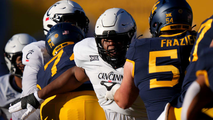 Cincinnati Bearcats defensive lineman Dontay Corleone (2) rushes the quarterback as West Virginia Mountaineers offensive lineman Zach Frazier (54) blocks in the first quarter during an NCAA college football game between the Cincinnati Bearcats and the West Virginia Mountaineers, Saturday, Nov. 18, 2023, at Milan Puskar Stadium in Morgantown, W. Va.