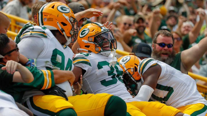 Green Bay Packers safety Anthony Johnson Jr. (36) does a Lambeau Leap with defensive lineman Karl Brooks (94) after returning a fumble for a touchdown against the Baltimore Ravens on Saturday.