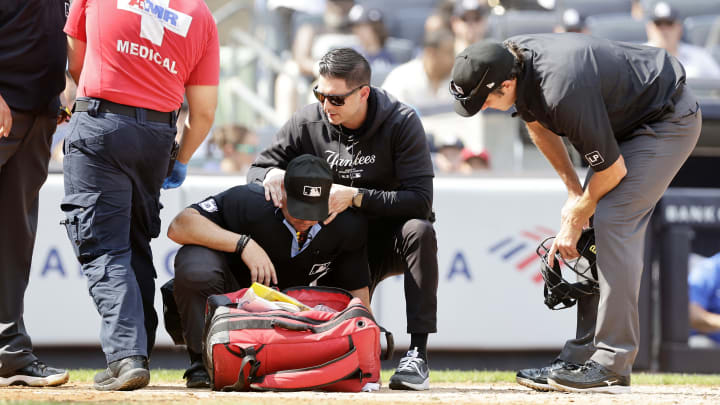 Home plate umpire Nick Mahrley is tended too after he was hit by a broken bat during a Giancarlo Stanton at-bat.