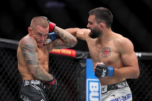 Benoit Saint Denis (blue gloves) fights Dustin Poirier (red gloves) during UFC 299 at Kayesa Center. 
